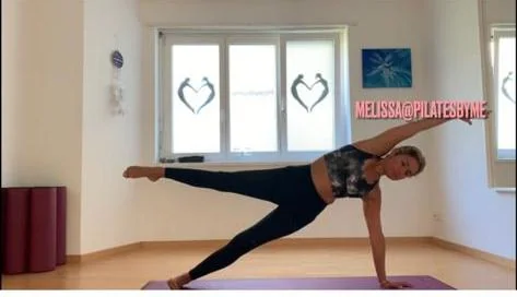 Pilatesbyme teacher demonstrating a side plank