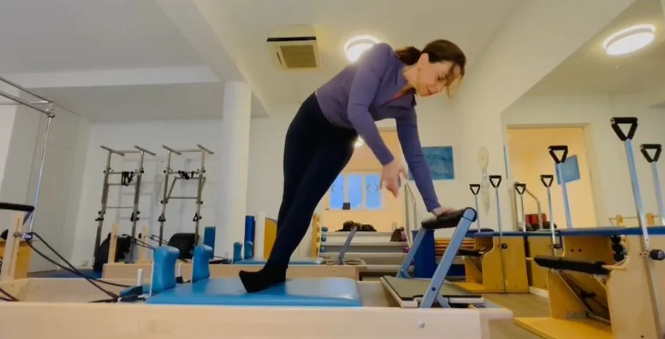 A teacher demonstrating a Reformer exercise at Pilatesbyme